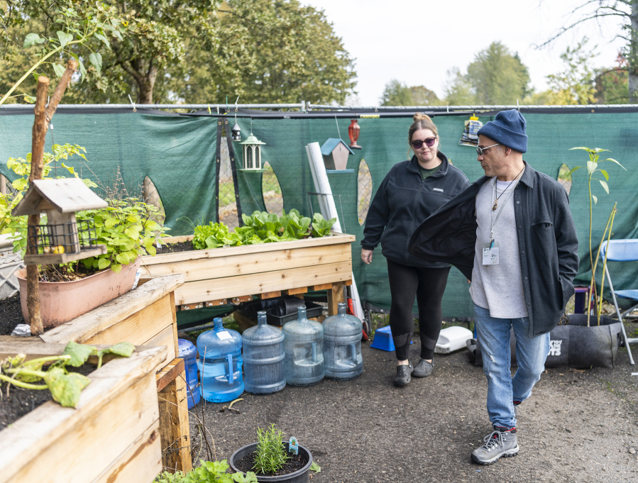 Outsiders Inn Executive Director Adam Kravitz, right, and The Outpost's Stephanie Eddy examine the transitional housing community's garden at The Outpost Safe Stay Community in east Vancouver.
