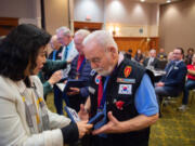 Consul General Eunji Seo gives Army veteran Edward Barnes a medal. More than a dozen Korean War veterans received medals at the event.