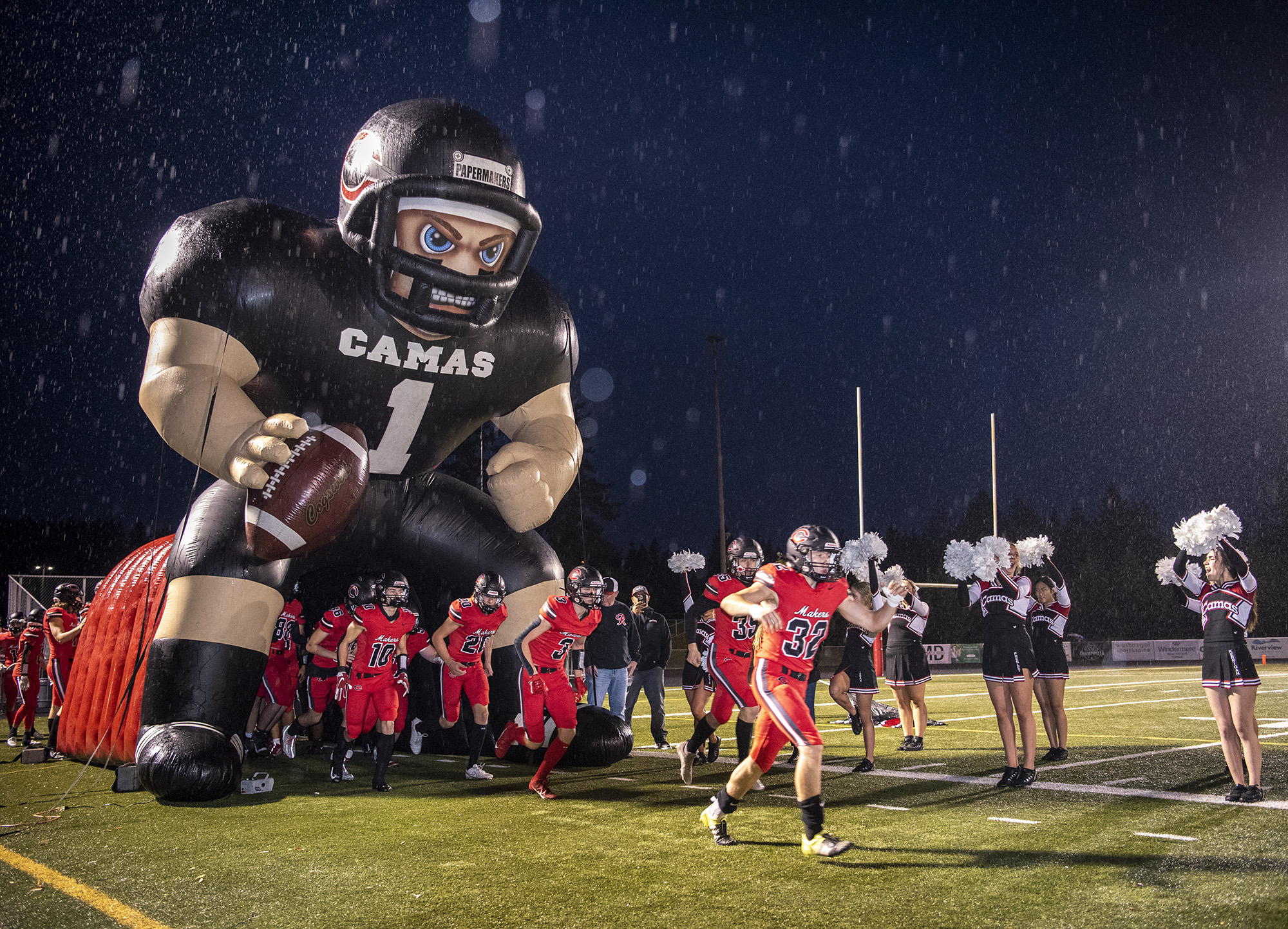 The Camas High School football team storms the field Friday, Oct. 13, 2023, before the Papermakers 21-9 win against Skyview at Doc Harris Stadium in Camas.