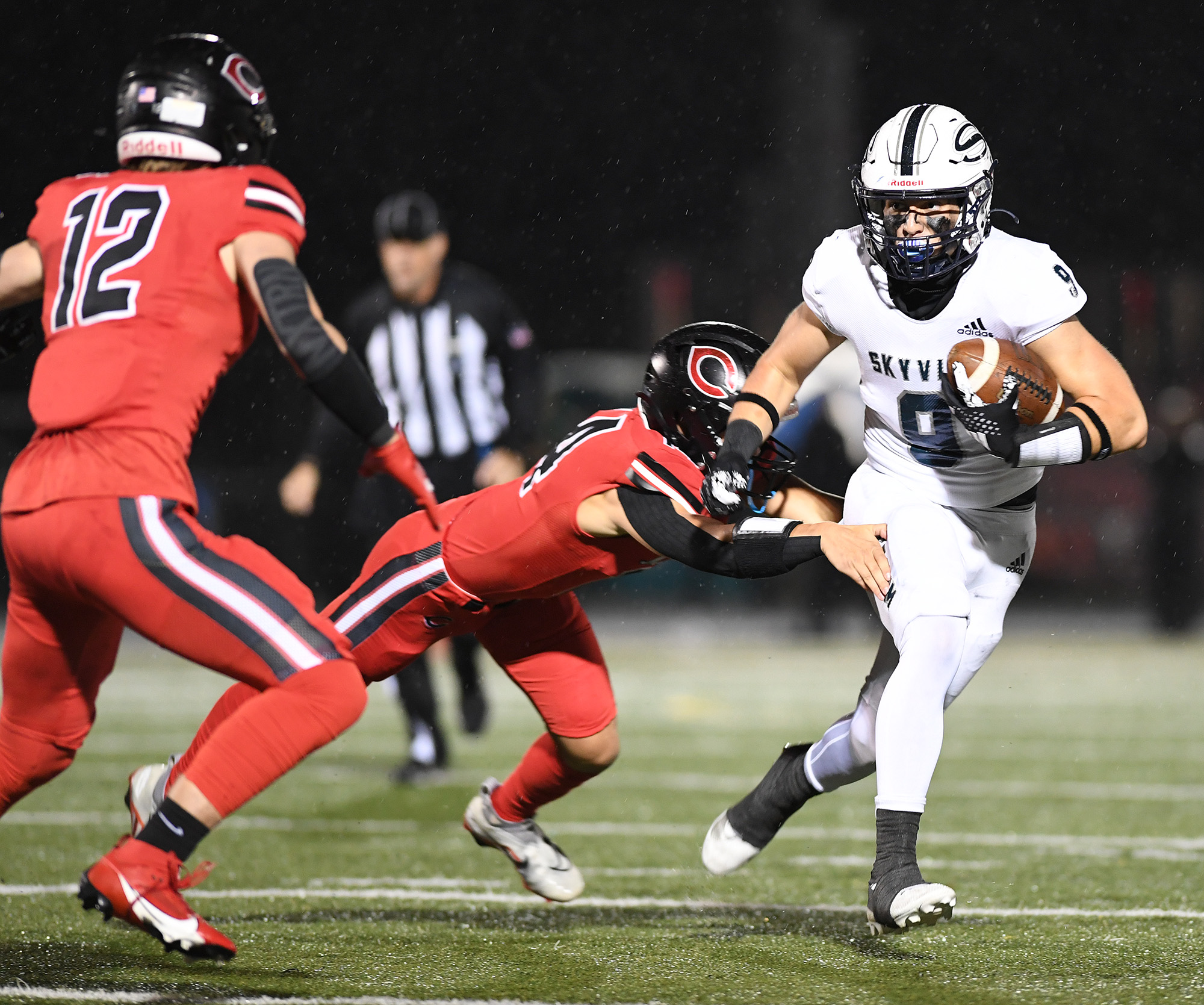 Skyview senior Gavin Poffenroth, right, evades a tackle Friday, Oct. 13, 2023, during the Storm’s 21-9 loss to Camas at Doc Harris Stadium in Camas.