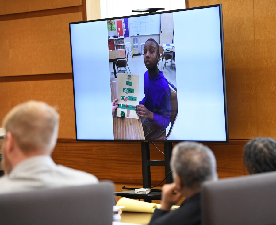 A school photo of Karreon Franks is displayed on a television Wednesday at the Clark County Courthouse during a murder trial. Karreon's adoptive parents Felicia Adams, right, and Jesse Franks, center, are being tried on second-degree murder and homicide by abuse in the 2020 death of the 15-year-old.