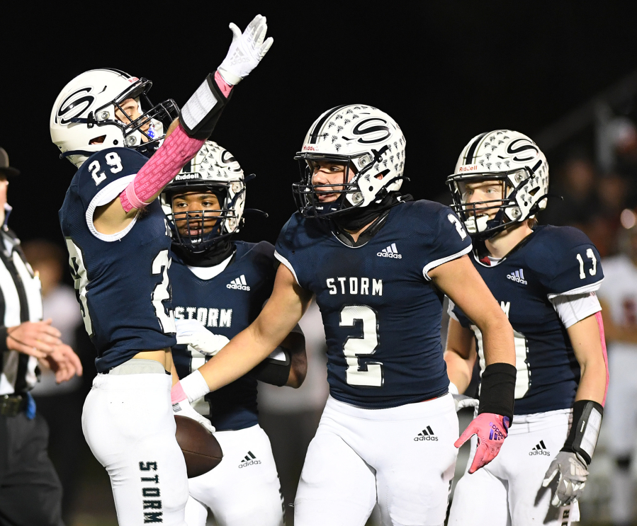 Skyview junior Micah Robison, left, celebrates an interception with teammates Friday, Oct. 20, 2023, during Skyview???s 49-10 win against Battle Ground at Kiggins Bowl.