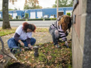 Fort Vancouver High School juniors Addison Miles, right, and Zamyrah Scott work on planting tulips. The tulips raise awareness of substance use in the community.