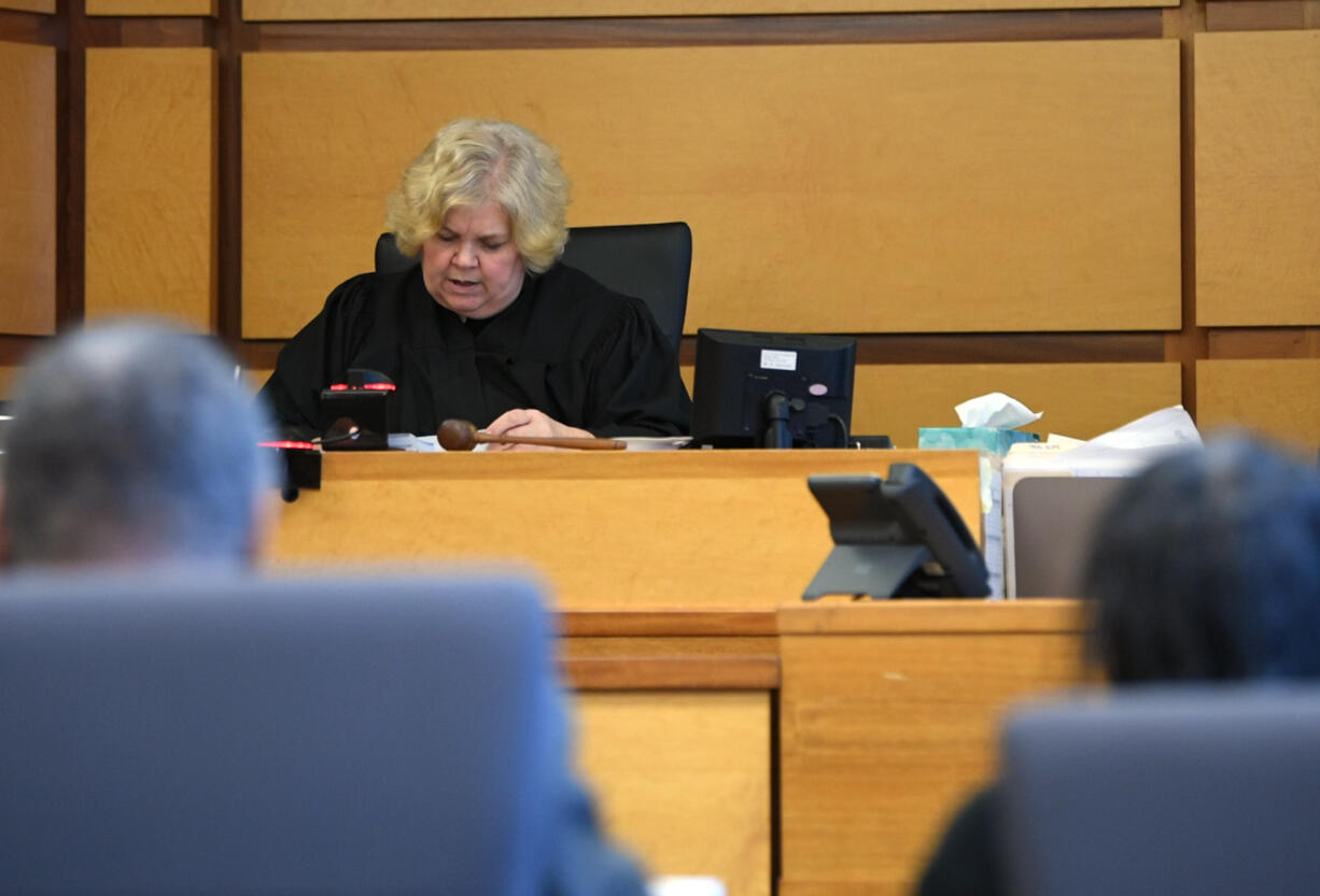 Clark County Superior Court Judge Suzan Clark, center, reads the verdict in the trial of Jesse Franks, left, and Felicia Adams, right, on Friday, Oct. 27, 2023, at the Clark County Courthouse. The jury found the pair guilty of homicide by abuse and murder in the 2020 death of their adopted son Karreon Franks.