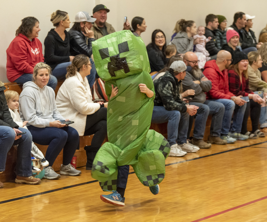 A student dressed as a "creeper" from Minecraft runs in front of parents Tuesday during a Halloween costume parade at Cape Horn-Skye Elementary School in Washougal.