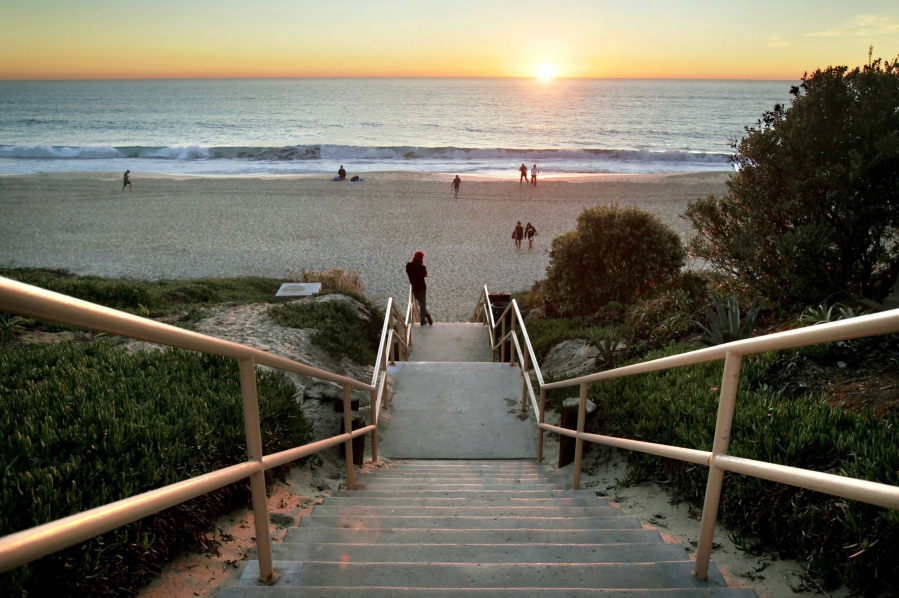 A man watches the sunset at the bottom of the beach stairs at the end of Carlsbad Village Drive.