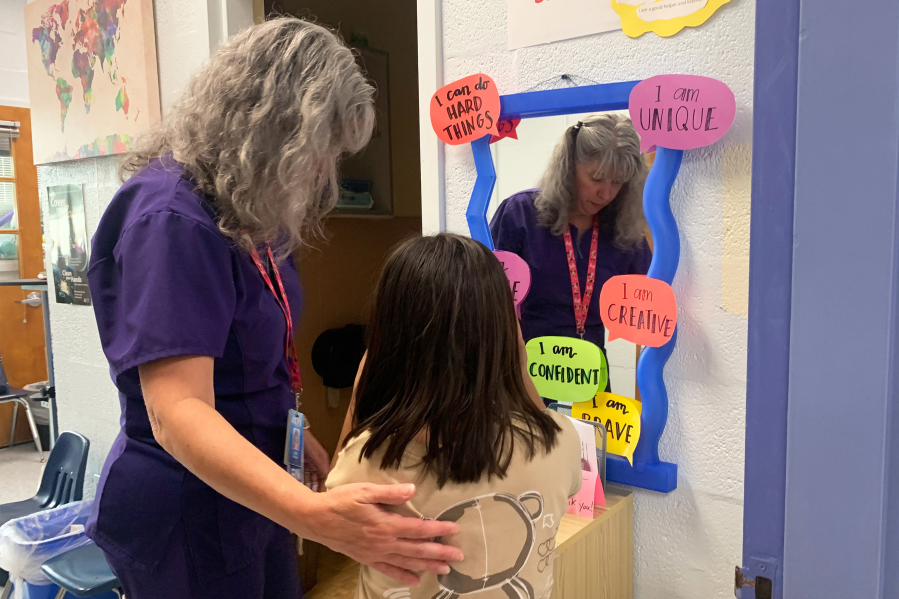 Nurse Jodi Bobbitt helps a youngster at William Ramsay Elementary in Alexandria, Va.