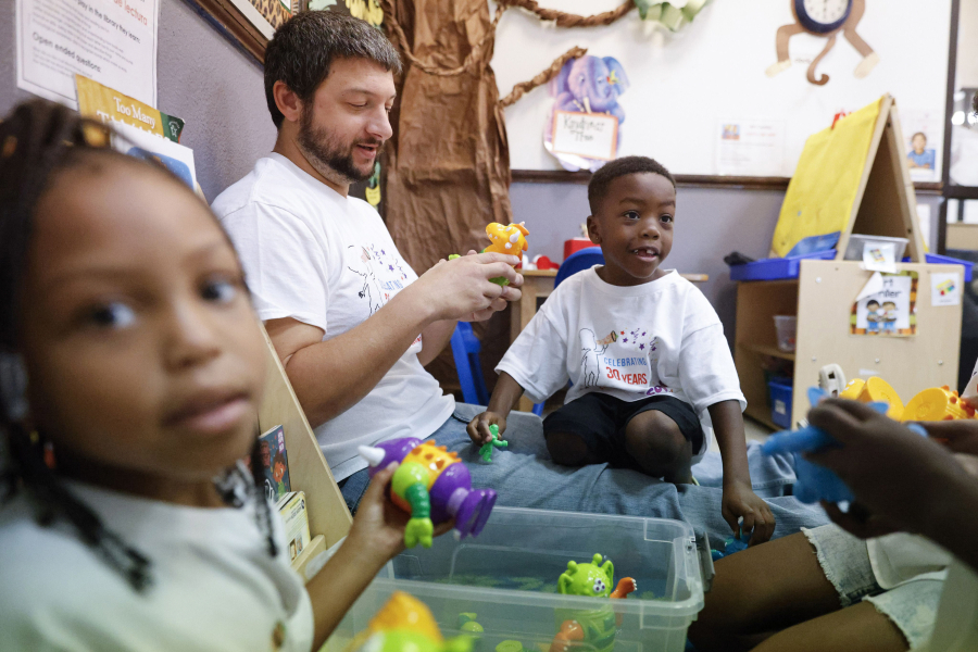Kennedi Ross (left) looks as pre-K teacher Charley Harris (center) plays with Kingston Ross in a classroom at Kaleidoscope Child Development Center in Dallas.