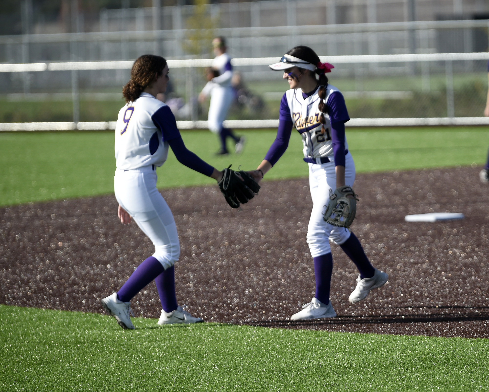 Columbia River shortstop Mia Yanez (21) is congratulated by outfield Sydney Seibert-Wilder (9) after Yanez made a diving play in the infield against Evergreen in the 3A/2A slowpitch softball district tournament at Heritage High School on Friday, Oct. 20, 2023.