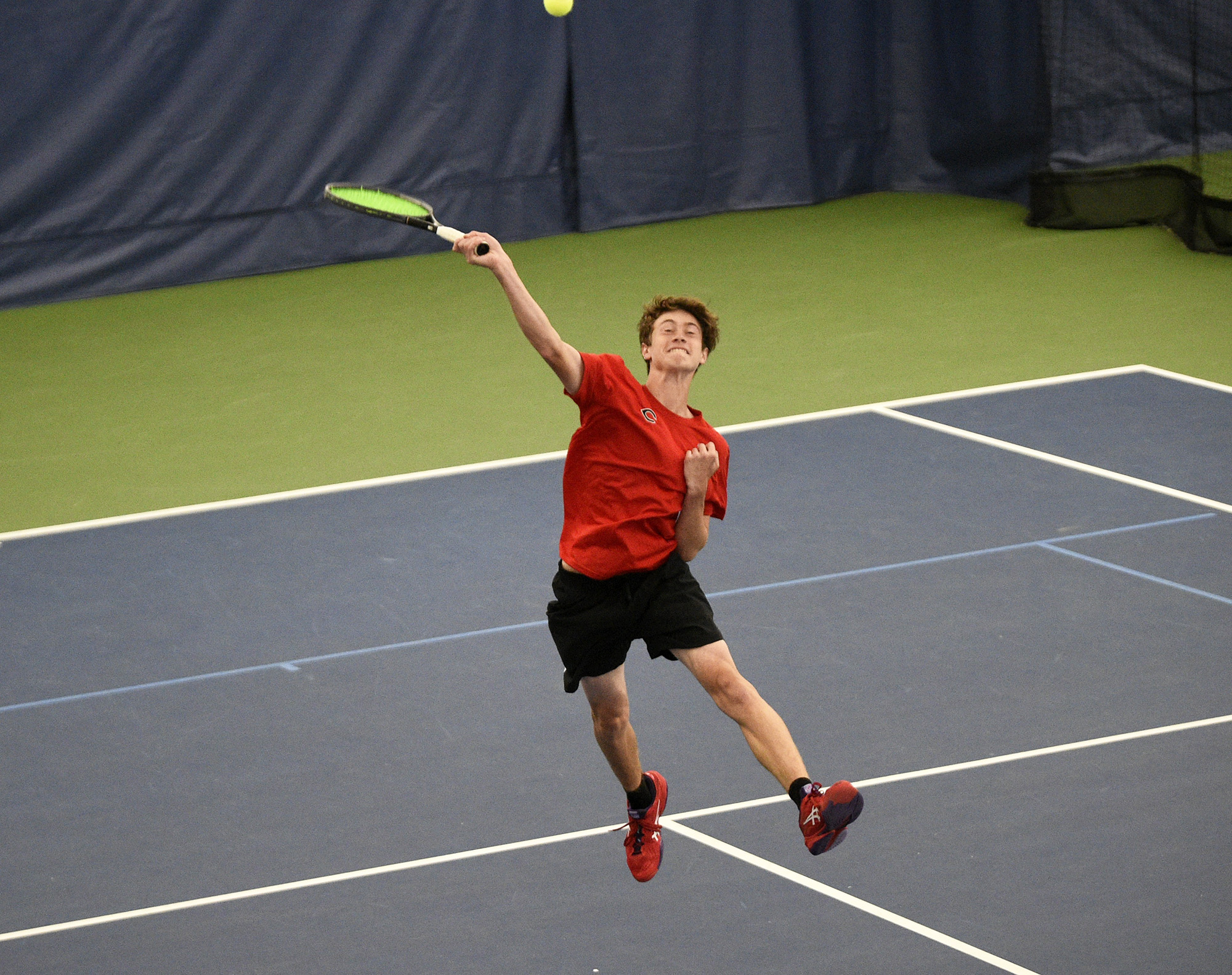 Aidan Brasier of Camas hits an overhead return in the doubles final at the Class 4A boys tennis district tournament at Vancouver Tennis Center on Saturday, Oct. 21, 2023.