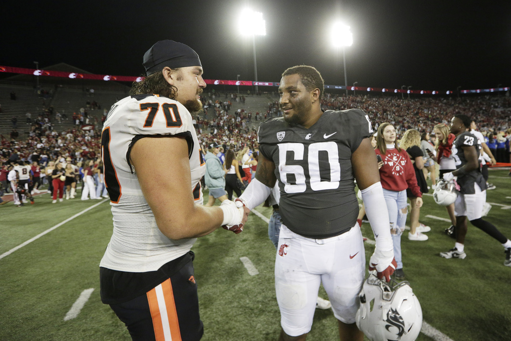 Oregon State offensive lineman Jake Levengood (70) and Washington State defensive tackle David Gusta (60) greet each other after an NCAA college football game, Saturday, Sept. 23, 2023, in Pullman, Wash.