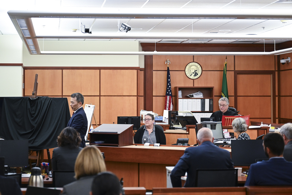 State assistant attorneys general Kent Liu, standing left, gives opening statements for the state's case during the trial of Tacoma Police Officers Christopher Burbank, Matthew Collins and Timothy Rankine in the killing of Manny Ellis, Tuesday, Oct. 3, 2023, at Pierce County Superior Court in Tacoma, Wash.