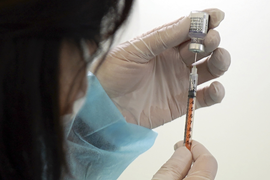 A health worker prepares a dose of the Pfizer COVID-19 vaccine.