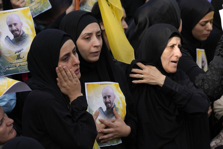 The wife, foreground, and the sister, center, of Hezbollah fighter Ali Ftouni who was killed by Israeli shelling, mourn as they attend his funeral procession in Kherbet Selem village, south Lebanon, Tuesday, Oct. 10, 2023. The Iran-backed group Monday night announced that three militants died following heavy Israeli shelling in border towns across southern Lebanon.