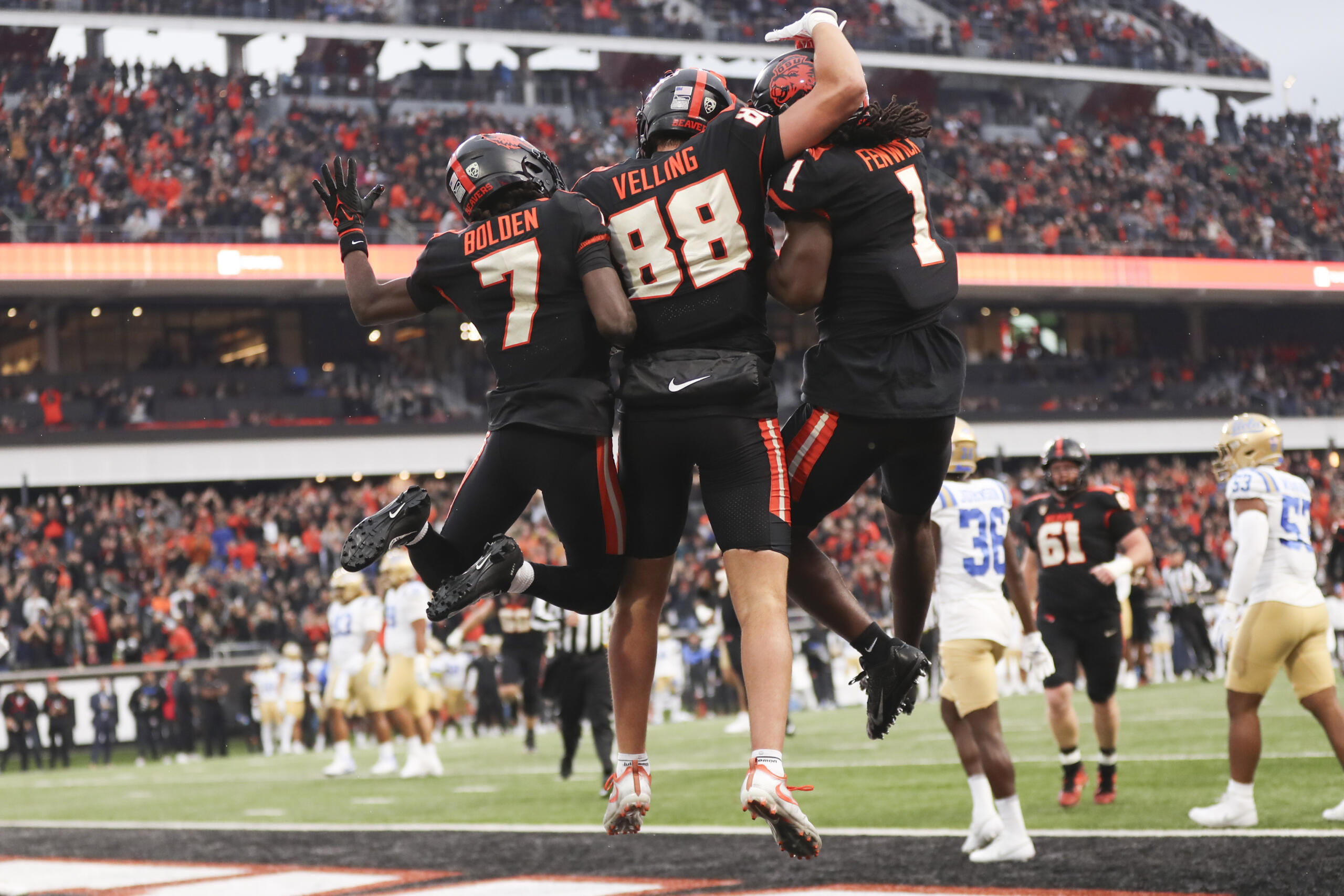 Oregon State tight end Jack Velling, center, celebrates after scoring a touchdown against UCLA with Silas Bolden, left, and Deshaun Fenwick, right, during the first half of an NCAA college football game Saturday, Oct. 14, 2023, in Corvallis, Ore.