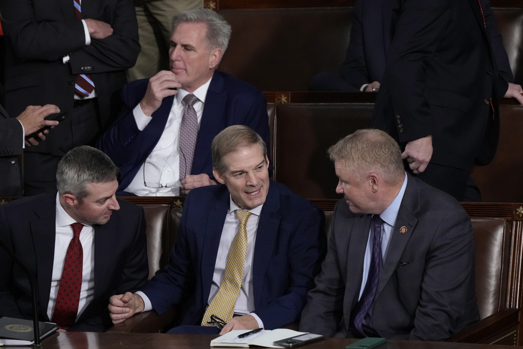 Rep. Jim Jordan, R-Ohio, chairman of the House Judiciary Committee, seated center, talks to Rep. Warren Davidson, R-Ohio, right, and a House staff member, left, as Republicans try to elect Jordan, a top Donald Trump ally, to be the new House speaker, at the Capitol in Washington, Tuesday, Oct. 17, 2023, as former Speaker of the House Rep. Kevin McCarthy, R-Calif., sits behind them. (AP Photo/J.