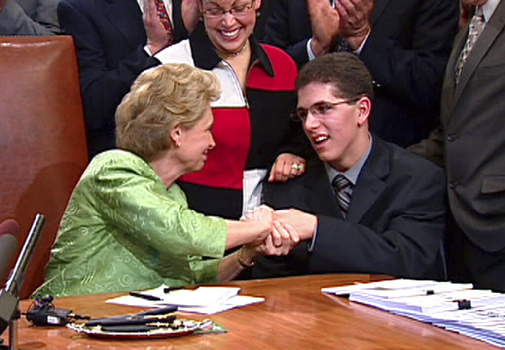 FILE - In this  May 14, 2009, file photo, made from video, then-Washington Gov. Chris Gregoire, left, shakes hands with Zackery Lystedt, right, in Olympia, Wash., after she signed the "Zackery Lystedt law", what is considered the nation's toughest law regulating when high school athletes can return to games after having sustained a concussion. It is named after Lystedt, who suffered a life-threatening brain injury in 2006 after he returned to play football following a concussion.