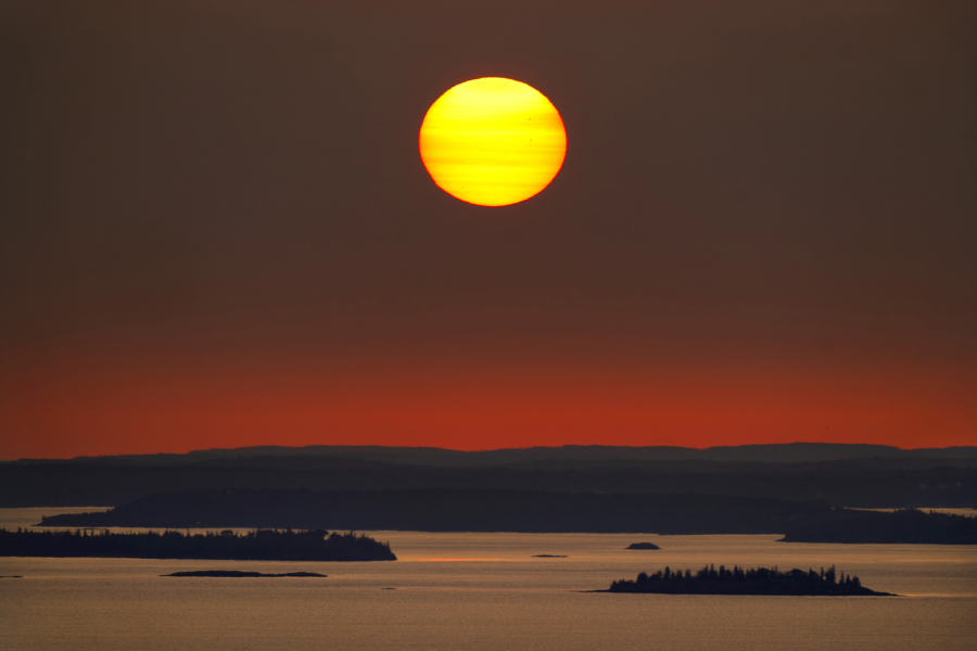The sun rises over Maine's Penobscot Bay, Wednesday, Sept. 27, 2023. Researchers with the National Oceanic and Atmospheric Administration say marine mammals are vulnerable to a variety of threats such as loss of habitat and food due to the consequences of warming waters. (AP Photo/Robert F.