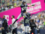 Seattle Seahawks wide receiver Jake Bobo (19) celebrates his touchdown catch against the Arizona Cardinals with Seahawks tight end Will Dissly (89) after an official review during the first half of an NFL football game Sunday, Oct. 22, 2023, in Seattle.