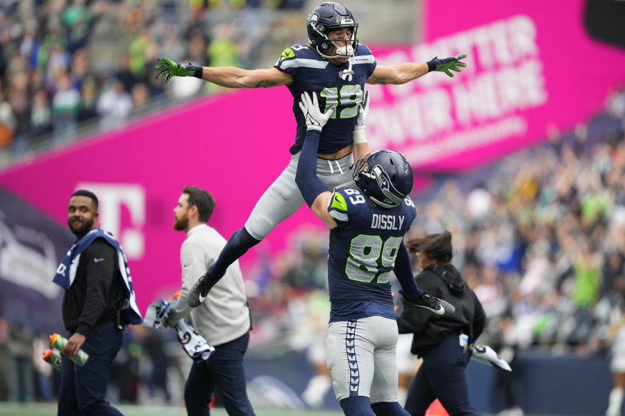 Seattle Seahawks wide receiver Jake Bobo (19) celebrates his touchdown catch against the Arizona Cardinals with Seahawks tight end Will Dissly (89) after an official review during the first half of an NFL football game Sunday, Oct. 22, 2023, in Seattle.