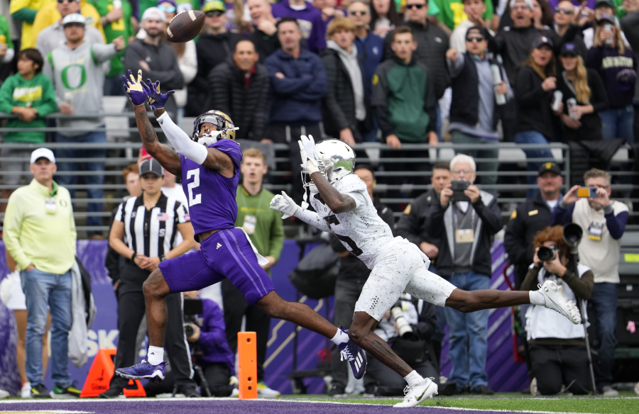Washington wide receiver Ja'Lynn Polk (2) makes a touchdown catch against Oregon defensive back Khyree Jackson, right, during the first half of an NCAA college football game, Saturday, Oct. 14, 2023, in Seattle.