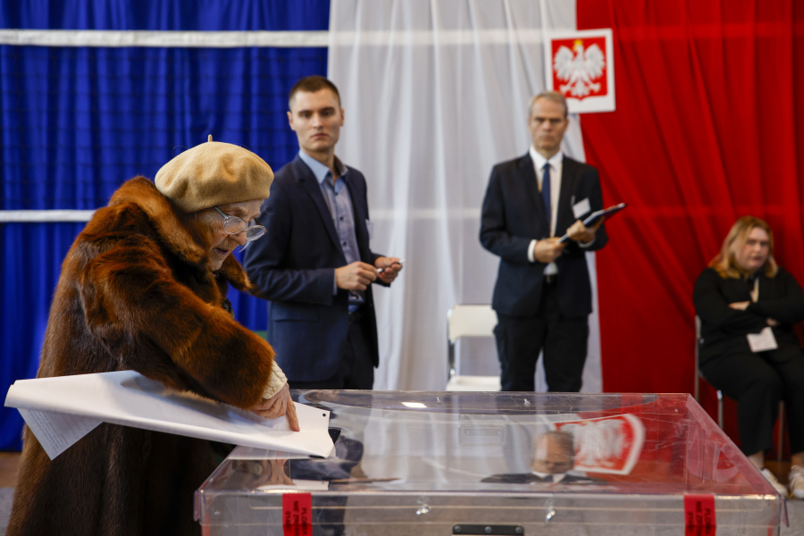 A woman casts her ballot during parliamentary elections in Warsaw, Poland, Sunday, Oct. 15, 2023. The outcome of Sunday's election will determine whether the right-wing Law and Justice party will win an unprecedented third straight term or whether a combined opposition can win enough support to oust it.