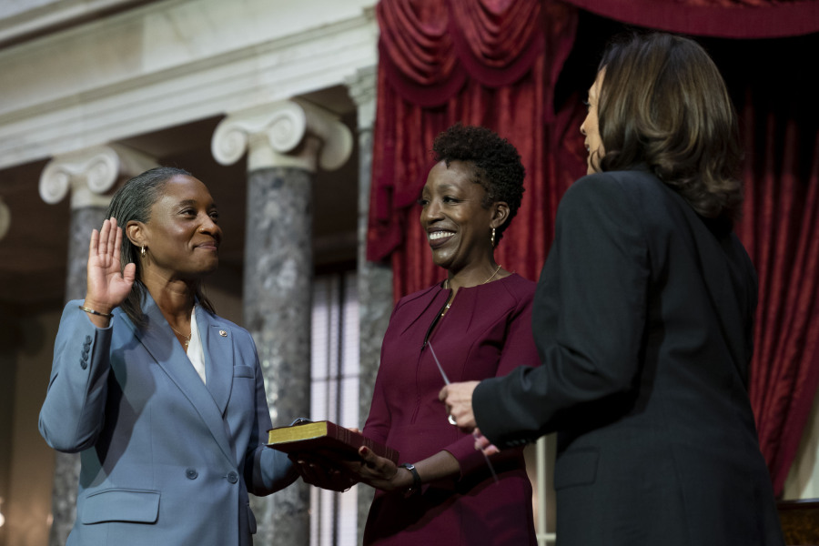 Vice President Kamala Harris, right, swears in Laphonza Butler, D-Calif., left, to the Senate to succeed the late Sen. Dianne Feinstein during a re-enactment of the swearing-in ceremony on Tuesday, Oct. 3, 2023, on Capitol Hill in Washington. Butler's wife, Neneki Lee, center, holds the Bible.