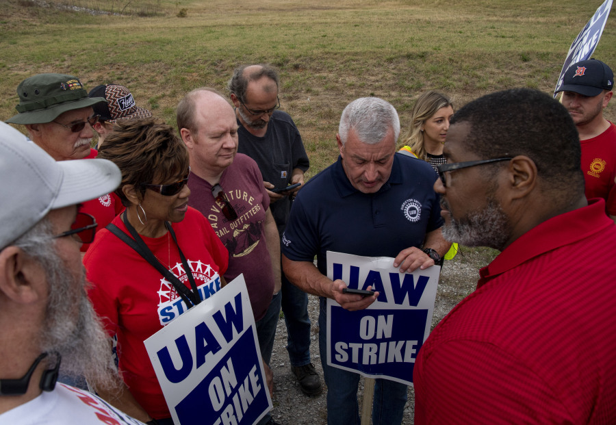 Tim Smith, center, UAW Region 8 director, stands outside with other workers as they listen to a phone call with UAW President Shawn Fain while picketing near the General Motors plant in Spring Hill, Tenn., after United Auto Workers Local 1853 announced a strike after 44 days of negotiations with GM, Sunday, Oct. 29, 2023.