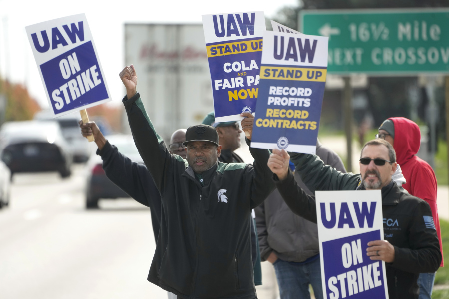 FILE - United Auto Workers members walk the picket line during a strike at the Stellantis Sterling Heights Assembly Plant, in Sterling Heights, Mich., Monday, Oct. 23, 2023. Jeep maker Stellantis has reached a tentative contract agreement with the United Auto Workers union that follows a template set earlier this week by Ford, two people with knowledge of the negotiations said Saturday, Oct. 28, 2023.