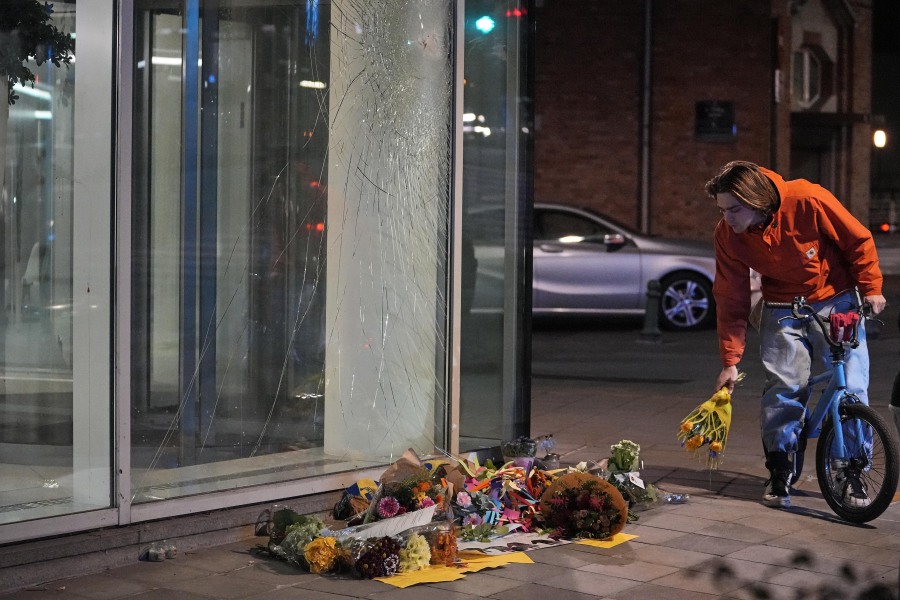Flowers laid in tribute outside an office building in Brussels, Tuesday evening, Oct. 17, 2023, close to where two Swedish soccer fans were shot by a suspected Tunisian extremist on Monday night. Police in Belgium have shot dead a suspected Tunisian extremist accused of killing two Swedish soccer fans in a brazen attack on a Brussels street before disappearing into the night on Monday.