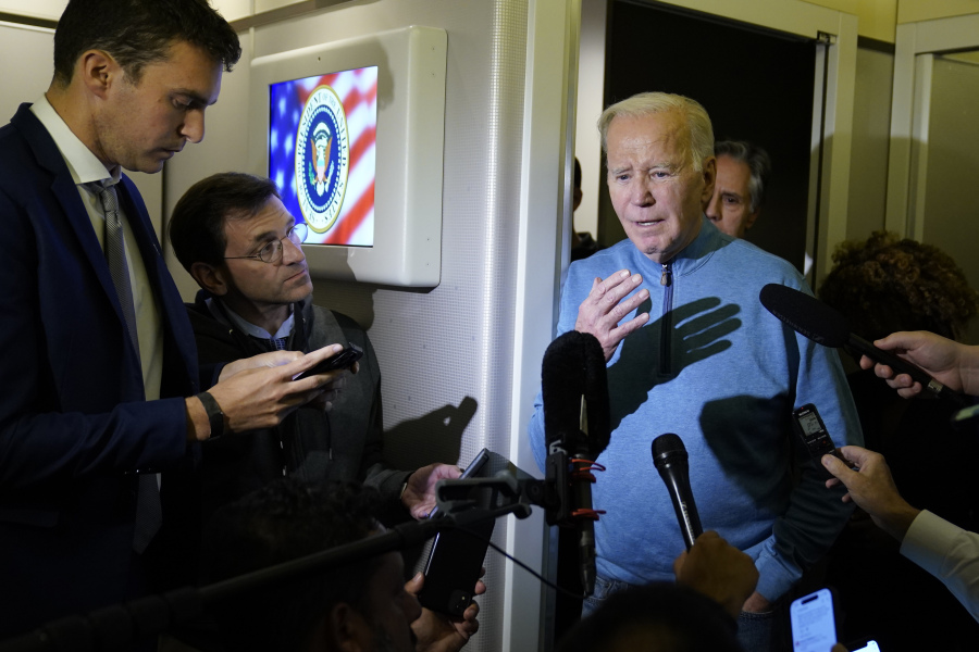 President Joe Biden talks to reporters aboard Air Force One during a refueling stop in at Ramstein Air Base in Germany, Wednesday, Oct. 18, 2023, as he travels back from Israel to Washington.