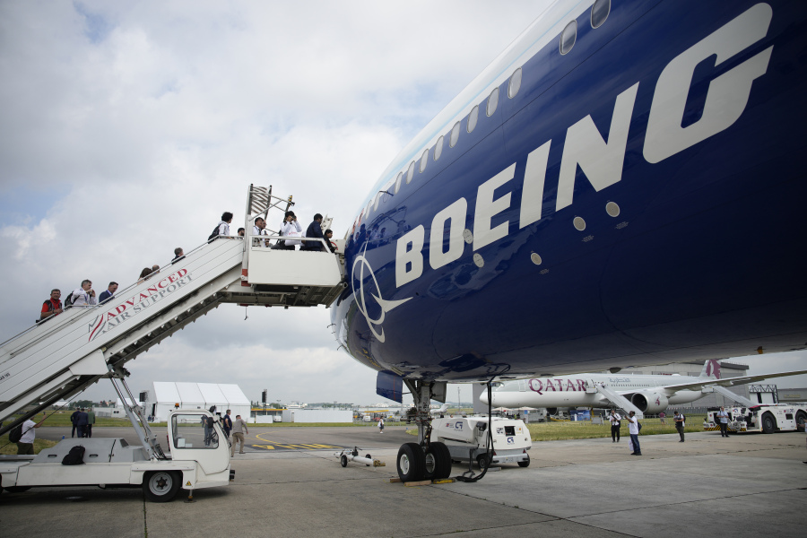 FILE - Visitors walk up the steps of the Boeing 777X airplane during the Paris Air Show in Le Bourget, north of Paris, France, Monday, June 19, 2023. Boeing deliveries of new airline jets slumped in the third quarter as the company struggled with production problems that are cutting into its ability to generate cash. Boeing said Tuesday, Oct. 10, 2023, that it delivered 27 planes in September, including 15 of its best-seller, the 737 Max.