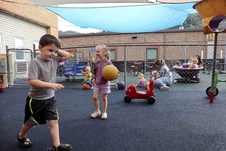 Children play on a rubber playground purchased in part with the support of pandemic-era stabilization aid at Living Water Child Care and Learning Center in Williamson, W.Va. on Monday, Sept. 25, 2023.