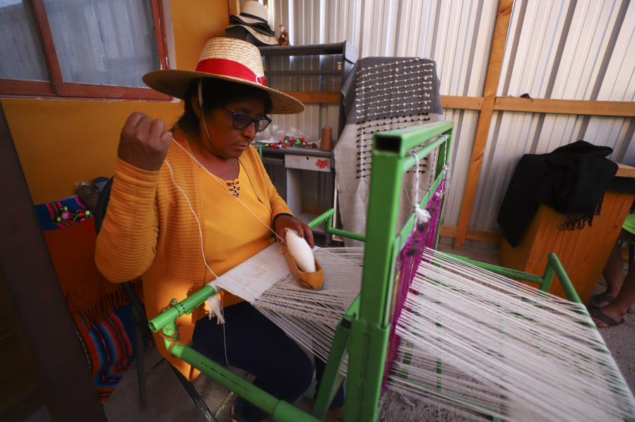 Marcelina Choque weaves on her loom at home in Pozo Almonte, Chile, Sunday, July 30, 2023.  "I taught my daughters how to weave just like me, but now that they have other jobs, they don't weave anymore," Choque said.
