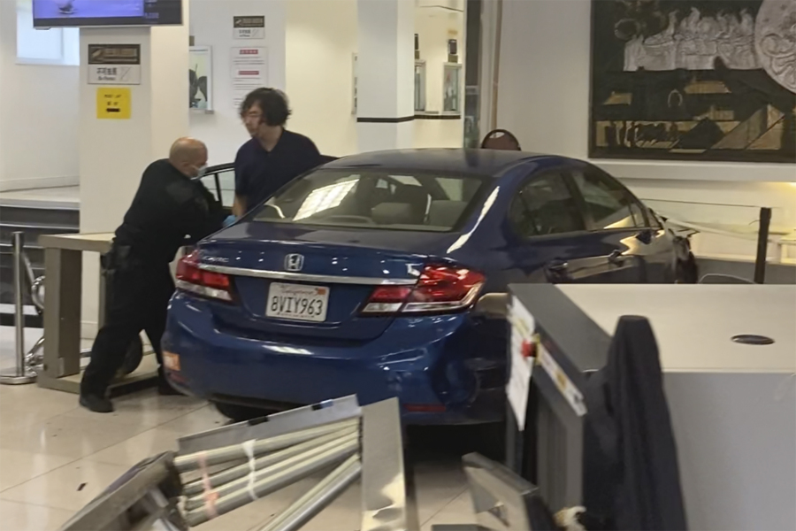 In this provided photo, a man gets out of his car after crashing into the lobby of the Chinese Consulate in San Francisco on Monday.