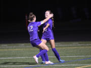 Columbia River’s Paige Johnson (12) celebrates with Avah Eslinger after Eslinger scored a goal in a 1-0 win over Ridgefield in a girls soccer match at Columbia River High School on Tuesday, Oct. 3, 2023.