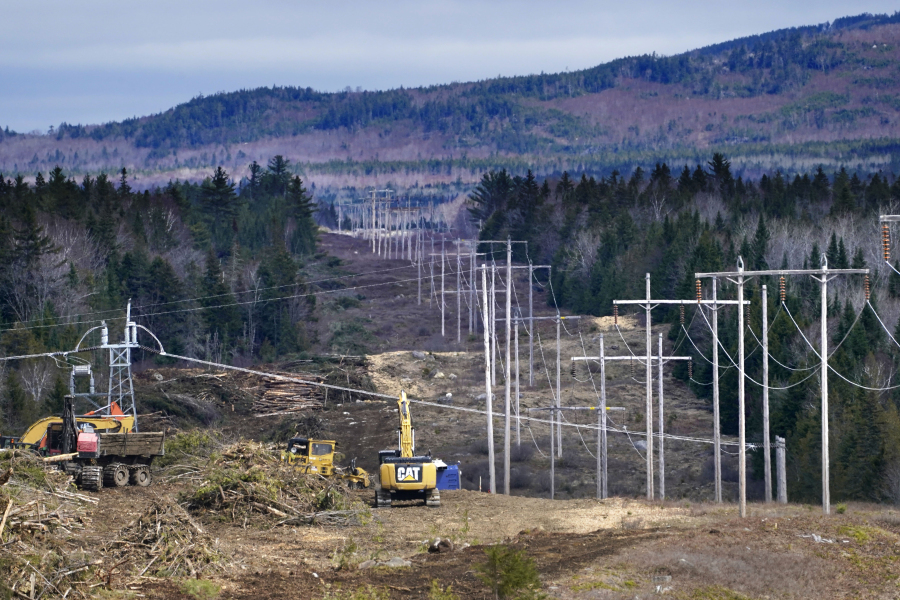 FILE - Heavy machinery is used to cut trees to widen an existing Central Maine Power power line corridor to make way for new utility poles, April 26, 2021, near Bingham, Maine. Stalled spending on electrical grids worldwide is slowing the rollout of renewable energy and could put efforts to limit climate change at risk if millions of miles of power lines aren't added or refurbished in the next few years. The International Energy Agency said in a report Tuesday that the capacity to connect to and transmit electricity isn't keeping pace with the rapid growth of clean energy technology like solar and wind power, electric cars and heat pumps. (AP Photo/Robert F.