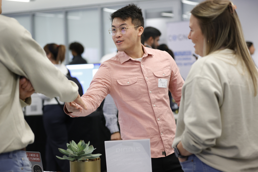 File - Georgia Tech student Michael Oh-Yang, center, greets company representatives at a job fair on March 29, 2023, in Atlanta. On Friday, the U.S. government issues its latest monthly jobs report.