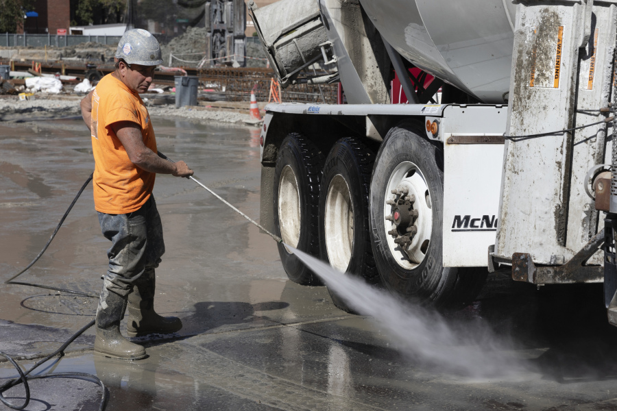A worker cleans a cement truck at a construction site, Friday, Sep. 1, 2023, in Boston. On Friday, the U.S. government issues its latest monthly jobs report.