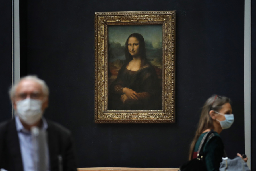 Journalists walk past Leonardo da Vinci's Mona Lisa during a visit of the Louvre museum Tuesday.