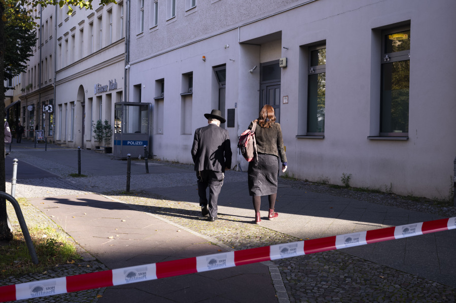 People enter the building complex of the Kahal Adass Jisroel community, which houses a synagogue, a kindergarten and a community center, in the center of Berlin, Germany, Wednesday, Oct. 18, 2023. The Kahal Adass Jisroel community said its synagogue in the city's Mitte neighborhood was attacked with two incendiary devices. Police confirmed the incident.
