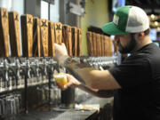 Adam Young, a bartender at Grains of Wrath Brewing, pours one of the house beers in 2018.