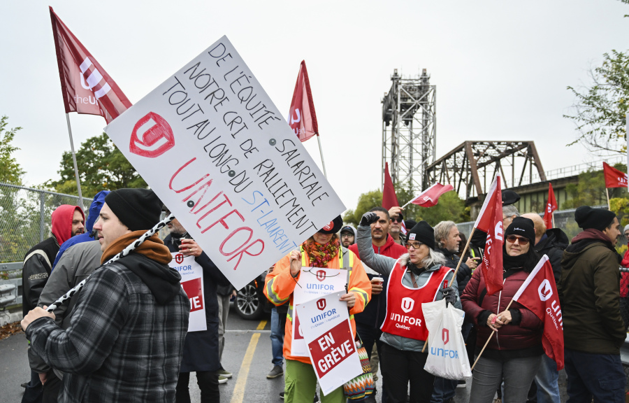 FILE - Striking St. Lawrence Seaway workers picket outside the St. Lambert Lock in St. Lambert, Quebec, Monday, Oct. 23, 2023. A deal was reached Sunday, Oct. 29, to end a week-long strike that had shut down a major shipping artery in the Great Lakes, halting the flow of grain and other goods from the U.S. and Canada.