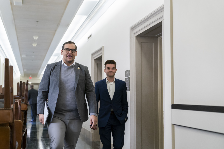 Rep. George Santos, R-N.Y., left, steps out of a closed-door meeting as Republicans decide who to nominate to be the new House speaker, Tuesday, Oct. 24, 2023, on Capitol Hill in Washington.