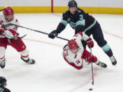 Carolina Hurricanes center Seth Jarvis (24) goes for the puck as Seattle Kraken defenseman Will Borgen (3) defends during the second period of an NHL hockey game Thursday, Oct. 19, 2023, in Seattle.