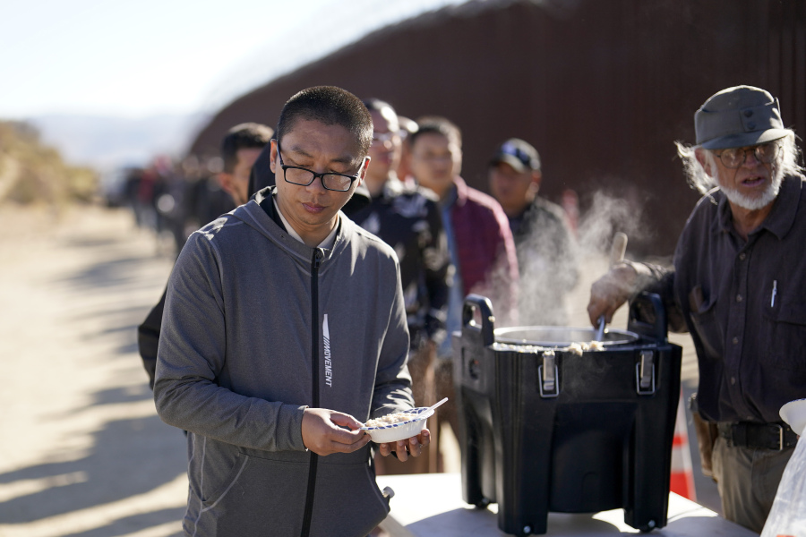 A man from China gets a bowl of oatmeal from a volunteer as he waits with others for processing to apply for asylum after crossing the border with Mexico, Tuesday, Oct. 24, 2023, near Jacumba, Calif. A major influx of Chinese migration to the United States on a relatively new and perilous route through Panama's Dari?n Gap jungle has become increasingly popular thanks to social media.