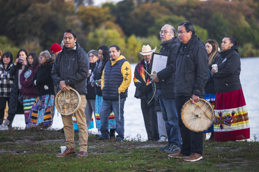 People attend an Indigenous People Sunrise ceremony at Bde Maka Ska Lake in Minneapolis, Minn. on Monday, Oct. 9, 2023.