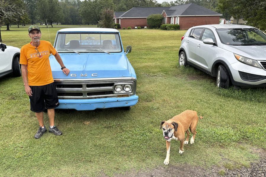 Ricky Dority poses for a photo with his 1969 GMC pickup and his family dog "Boots" outside his family's home in Greenwood, Ark., on Friday, Sept. 22, 2023. Dority was freed from prison this summer with the help of students from Oklahoma City University's Innocence Project.