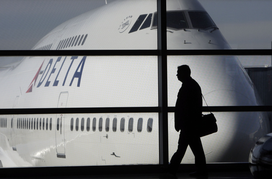 FILE - In this file photo made Jan. 21, 2010, a passenger walks past a Delta Airlines 747 aircraft in McNamara Terminal at Detroit Metropolitan Wayne County Airport in Romulus, Mich. Major airlines are suspending flights to Israel after it formally declared war following a massive attack by Hamas. American Airlines, United Airlines and Delta Air Lines suspended service as the U.S. State Department issued travel advisories for the region citing potential for terrorism and civil unrest. Delta said its Tel Aviv flights have been canceled into this week.