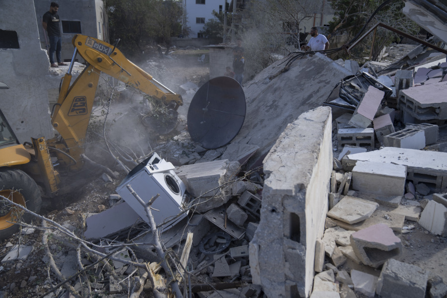 A bulldozer clears the rubble at the site of the demolished family home of Saleh al-Arouri, in the West Bank village of Arura, northwest of Ramallah, Tuesday, Oct. 31, 2023. In the occupied West Bank, where Israeli-Palestinian violence has surged, the Israeli army demolished the family home of Saleh al-Arouri, a senior Hamas official exiled over a decade ago. Ali Kaseeb, head of the local council in the village of Aroura, said the home had been vacant for 15 years.